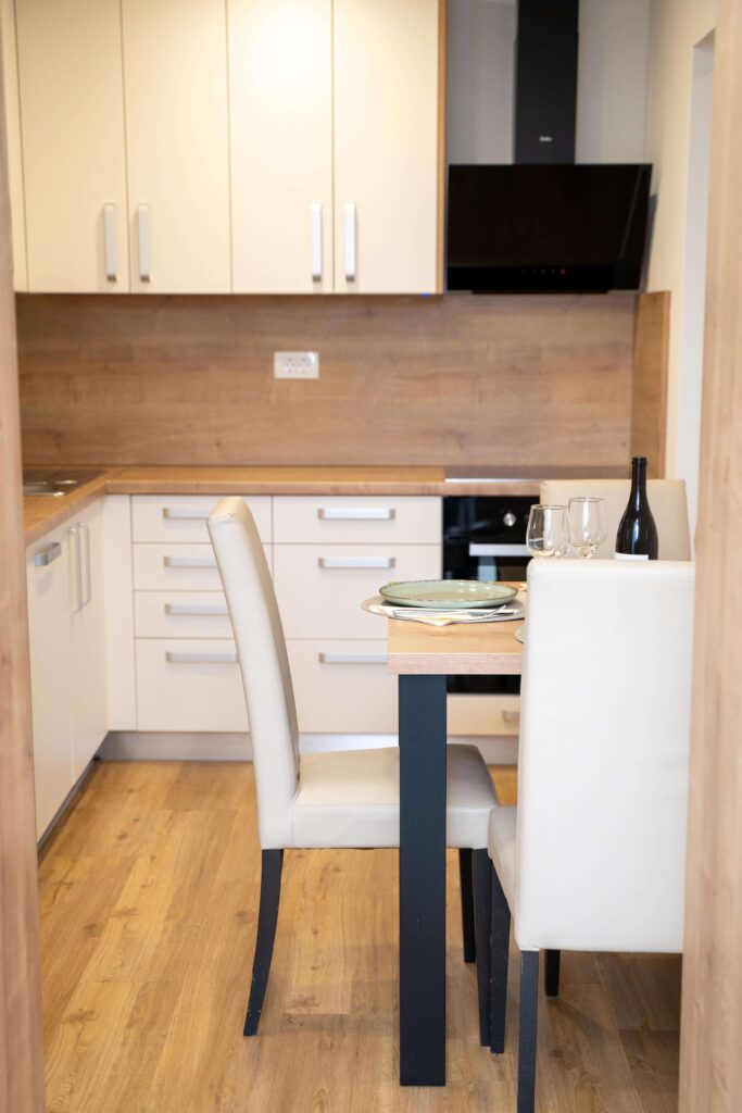 Jedilni prostor apartmaja v Oplotnici – miza in stoli ob kuhinji v Edi Residence