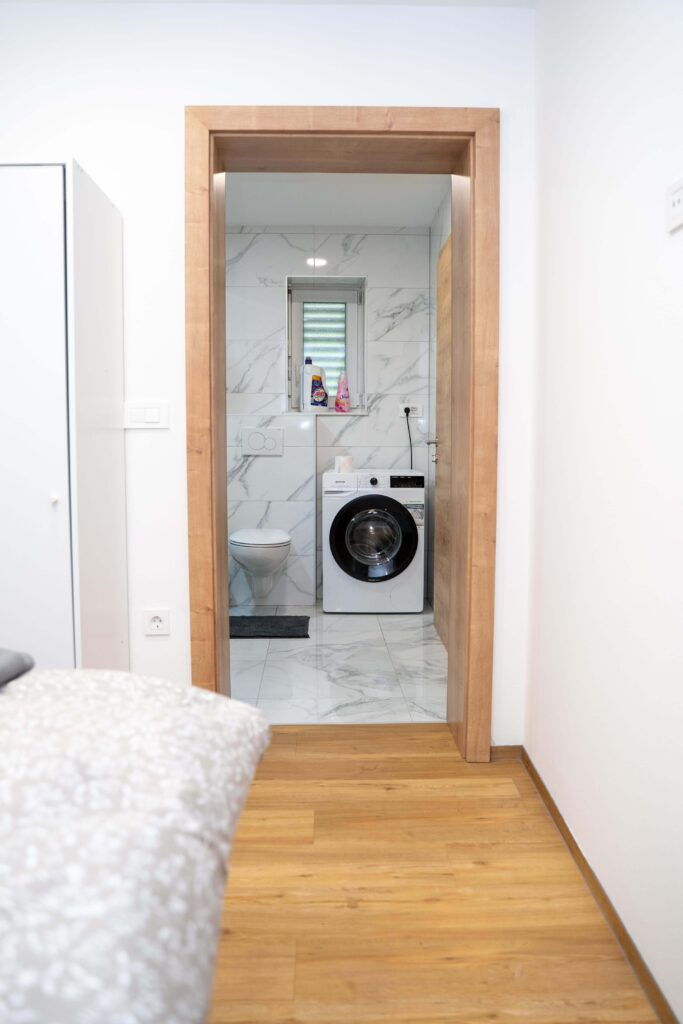 Kopalnica apartmaja v Oplotnici s pralnim strojem in WC-jem v Edi Residence