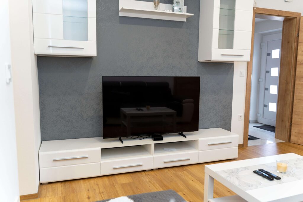 Svetla dnevna soba apartmaja v Oplotnici s sedežno garnituro in oknom
